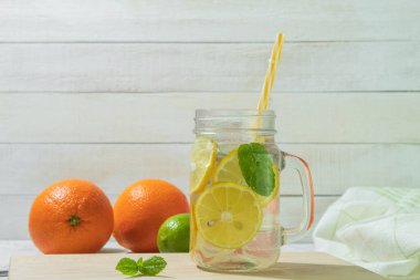 Köy arka planında naneli taze limonata. Limonata ve ahşap arka plandaki malzemeler, kopyalama alanı. Limonlu yaz limonatası ve sarı, güneşli bir arka planda nane.