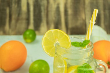 Köy arka planında naneli taze limonata. Limonata ve ahşap arka plandaki malzemeler, kopyalama alanı. Limonlu yaz limonatası ve sarı, güneşli bir arka planda nane.