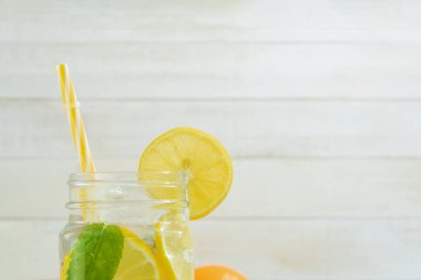 Köy arka planında naneli taze limonata. Limonata ve ahşap arka plandaki malzemeler, kopyalama alanı. Limonlu yaz limonatası ve sarı, güneşli bir arka planda nane.