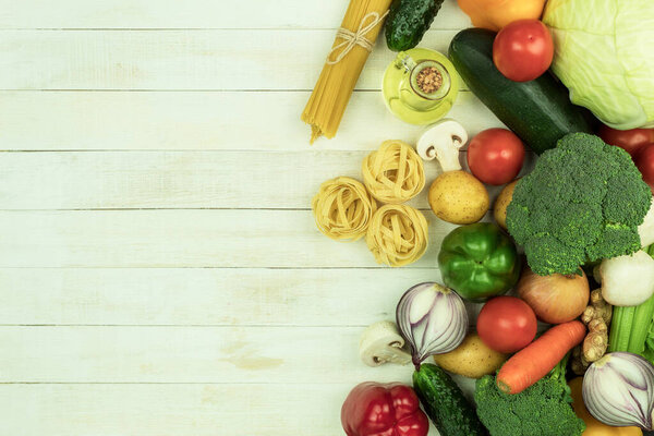 Dry and cheesy pasta with vegetables on the table. Mixed selection of dried pasta on a wooden background. copy space