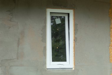 Yeni binadaki beyaz metal-plastik pencere. Pencere kurulum süreci. Kopyalama alanı olan arkaplan
