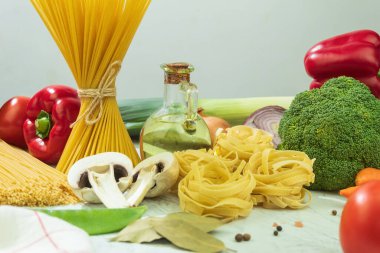 Sebzeli, kuru ve peynirli makarna. Ahşap arka planda kurutulmuş makarna seçimi. Boşluğu kopyala