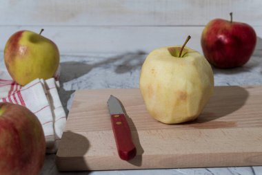 Mutfak tezgahında soyulmuş kırmızı elma, yan manzara. Kopya alanı olan bir arkaplan. Sanatsal gıda konsepti