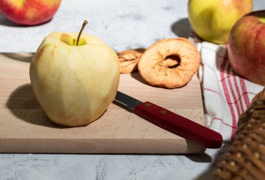 Mutfak tezgahında soyulmuş kırmızı elma, yan manzara. Kopya alanı olan bir arkaplan. Sanatsal gıda konsepti