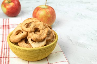 Masada taze elmalar ve kurutulmuş elmalar var. Kopya alanı olan bir arkaplan. Mutfak tezgahında sanatsal gıda konsepti