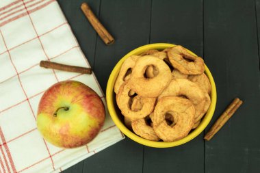 Masada taze elmalar ve kurutulmuş elmalar var. Kopya alanı olan bir arkaplan. Mutfak tezgahında sanatsal gıda konsepti