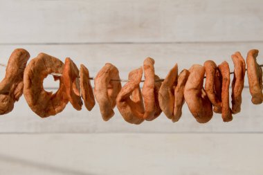 Elma dilimleri bir iple kurutulur. Kopya alanı olan bir arkaplan. Sanatsal gıda konsepti