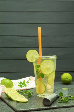 Tahta bir masada taze ve soğuk narenciye içeceği. Ev yapımı portakal ve limonlu buzlu çay. Kopyalama alanı olan arkaplan