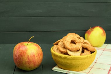 Masada taze elmalar ve kurutulmuş elmalar var. Kopya alanı olan bir arkaplan. Mutfak tezgahında sanatsal gıda konsepti