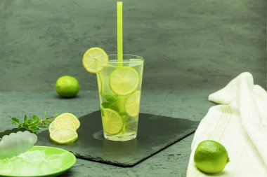 Tahta bir masada taze ve soğuk narenciye içeceği. Ev yapımı portakal ve limonlu buzlu çay. Kopyalama alanı olan arkaplan