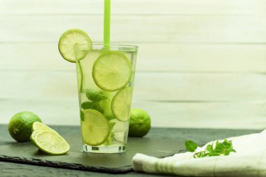 Tahta bir masada taze ve soğuk narenciye içeceği. Ev yapımı portakal ve limonlu buzlu çay. Kopyalama alanı olan arkaplan