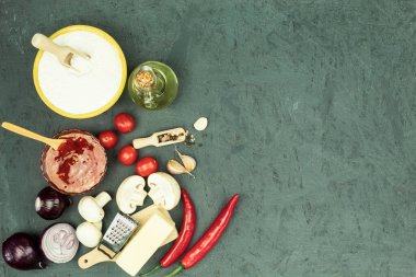 Pizza yapmak için gerekli malzemeler masada. Pizza pişirme süreci: hamur, merdane, yumurta, tereyağı ve buğday unu ahşap bir masada. Metin için alanı olan arkaplan