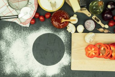 Pizza yapmak için gerekli malzemeler masada. Pizza pişirme süreci: hamur, merdane, yumurta, tereyağı ve buğday unu ahşap bir masada. Metin için alanı olan arkaplan