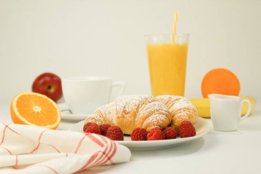 Kruvasan ve taze ahududu, taze ve lezzetli kruvasanlar. Otelde kahvaltı: sütlü kahve ve kruvasan, ahududu ve ahşap masa. Kopyalama alanı olan arkaplan