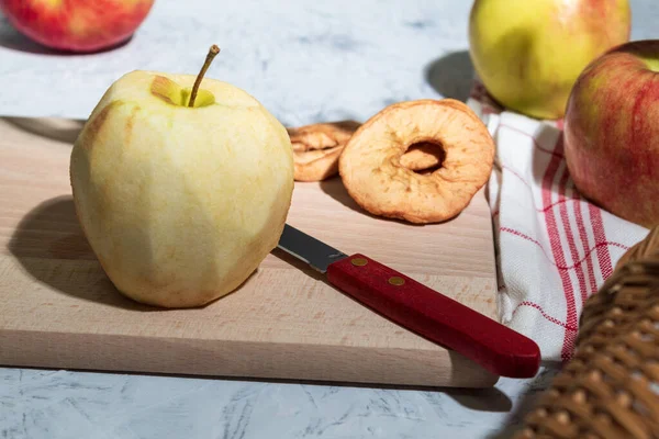 Masada taze elmalar ve kurutulmuş elmalar var. Kopya alanı olan bir arkaplan. Mutfak tezgahında sanatsal gıda konsepti