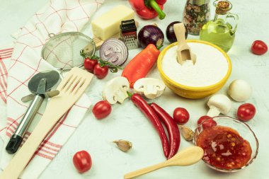 Pizza yapmak için gerekli malzemeler masada. Pizza pişirme süreci: hamur, merdane, yumurta, tereyağı ve buğday unu ahşap bir masada. Metin için alanı olan arkaplan