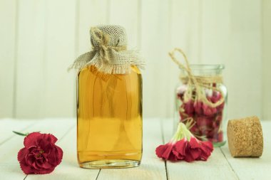 Taze çiçek yapraklarından yapılmış bir şişe aromatik yağ. Karanfillerden elde edilen temel yağ. Kopyalama alanı olan arkaplan