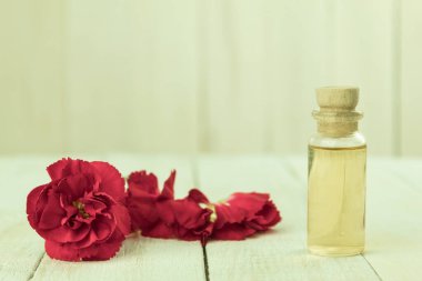 Taze çiçek yapraklarından yapılmış bir şişe aromatik yağ. Karanfillerden elde edilen temel yağ. Kopyalama alanı olan arkaplan