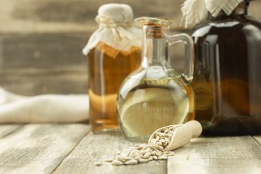 Kokulu ayçiçeği yağlı bir şişe ve metin için alanı olan bir arka plan. Yakından, ayçekirdeği ve ayçiçeği yağı küçük bir sürahide.