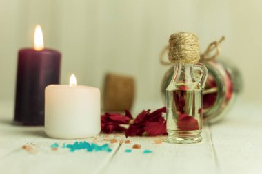 Aroma yağı şişesi ve aroma mumları. Arka planda mesaj için yer var. Yakın plan, şişedeki yağ ve arka plandaki spa mumları. Spa, arka planda mumlar.