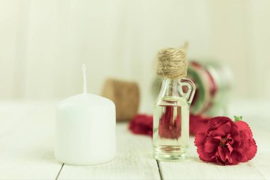 Aroma yağı şişesi ve aroma mumları. Arka planda mesaj için yer var. Yakın plan, şişedeki yağ ve arka plandaki spa mumları. Spa, arka planda mumlar.