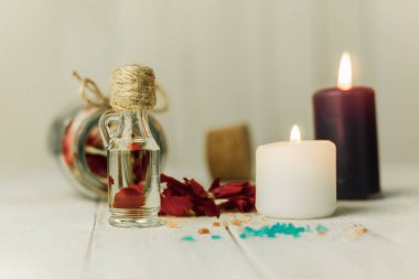 Aroma yağı şişesi ve aroma mumları. Arka planda mesaj için yer var. Yakın plan, şişedeki yağ ve arka plandaki spa mumları. Spa, arka planda mumlar.