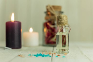 Aroma yağı şişesi ve aroma mumları. Arka planda mesaj için yer var. Yakın plan, şişedeki yağ ve arka plandaki spa mumları. Spa, arka planda mumlar.
