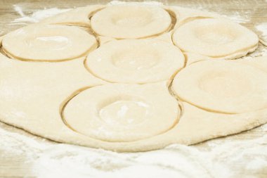 Hamur, masanın üzerine pasta şeklinde yuvarlandı. Pişirme hamuru rulo haline getirilip pastaya dönüştürülüyor. Kopyalama alanı olan arkaplan