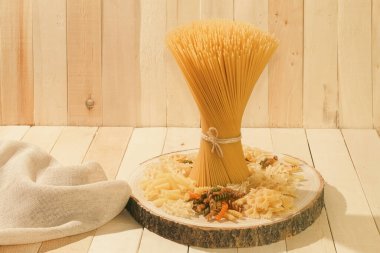 Çiğ spagetti ve fotokopi alanı olan arka plan. Uzun spagetti. Ahşap arka planda çiğ spagetti.