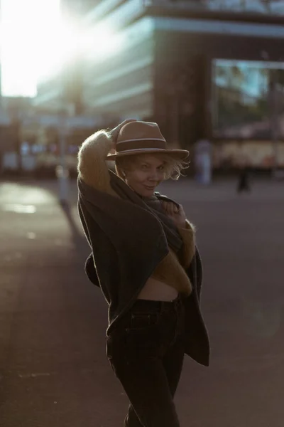 大都市の中心部に短い散髪と帽子の美しい中年の女性 クローズアップ肖像画 ソフトバックライト — ストック写真