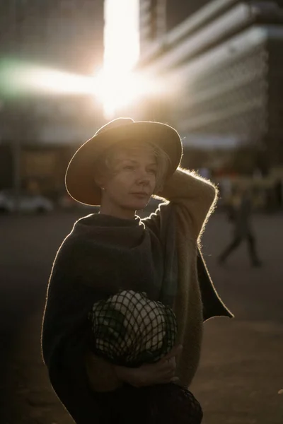 大都市の中心部に短い散髪と帽子の美しい中年の女性 クローズアップ肖像画 ソフトバックライト — ストック写真