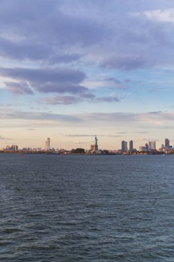Gün batımında sudan Özgürlük Anıtı manzarası, New York