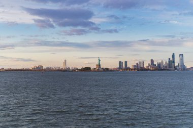 Gün batımında sudan Özgürlük Anıtı manzarası, New York