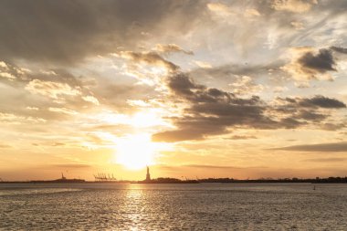 Gün batımında sudan Özgürlük Anıtı manzarası, New York