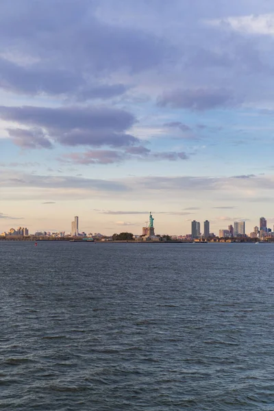 ニューヨークの日没時の水からの自由の女神像の眺め — ストック写真