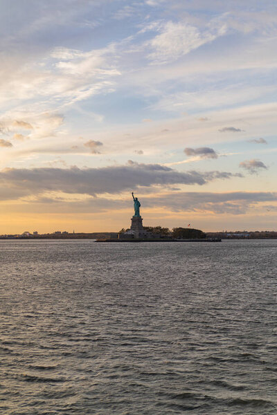 View of the Statue of Liberty from the water at sunset, New York