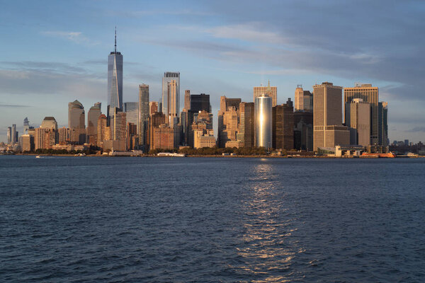 Ferry to Manhattan. View of Manhattan from the water at sunset,