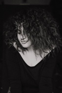 Kıvırcık saçlı, duygusal portresi olan, yakın plan, siyah beyaz fotoğraflı güzel esmer kadın..