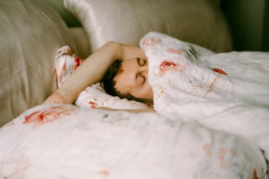 Adam yatakta, sabah, uyanıyor, yatakta tembellik ediyor.