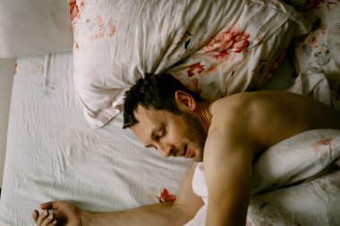 Adam yatakta, sabah, uyanıyor, yatakta tembellik ediyor.