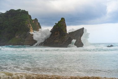 Tropik sahil manzarası, deniz taşları ve turkuaz okyanus, mavi gökyüzü..