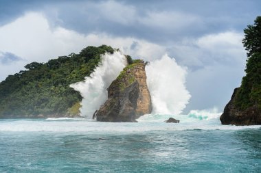 Tropik sahil manzarası, deniz taşları ve turkuaz okyanus, mavi gökyüzü..