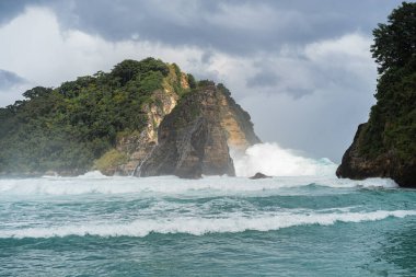 Tropik sahil manzarası, deniz taşları ve turkuaz okyanus, mavi gökyüzü..