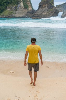 Genç yakışıklı sakallı adam okyanus kenarında gezgin. Atuh plajı, Nu.