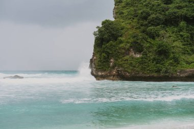 Tropik sahil manzarası, deniz taşları ve turkuaz okyanus, mavi gökyüzü..
