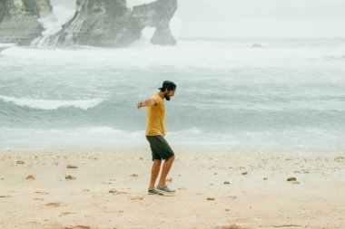 Genç yakışıklı sakallı adam okyanus kenarında gezgin. Atuh plajı, Nu.