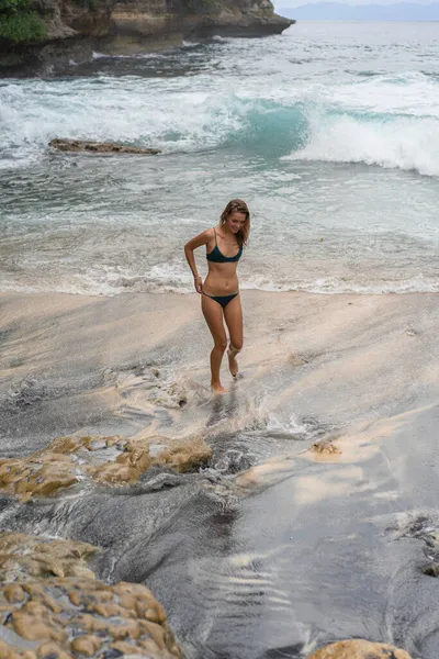 海の近くのビーチで水着で長いブロンドの髪を持つ美しい若い細い女性 ビーチでリラックスしてください 熱帯の休暇だ 女が泳いで水の中に入る — ストック写真