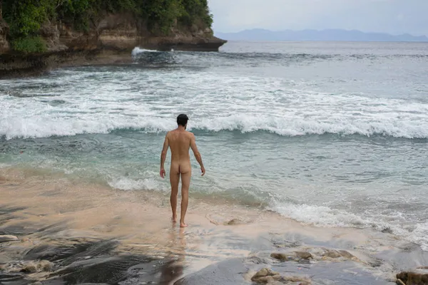 Naked man on the ocean. The unity of man with nature.