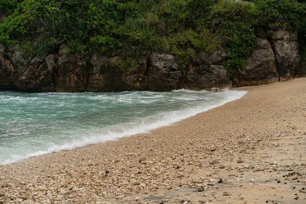 自然の背景青い海波が海岸に流れ崖の端が緑豊かな熱帯植物で — ストック写真