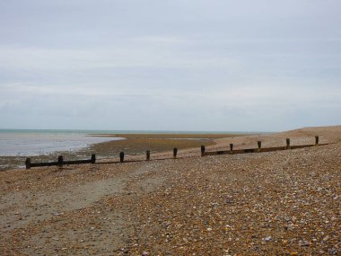 Denizin ve dalgaların olduğu sessiz bir çakıl taşı kumsalı manzarası